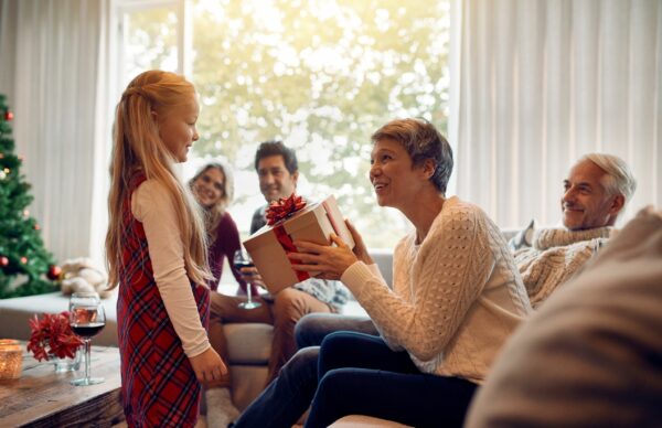Senior woman receiving a Christmas gift from her granddaughter.