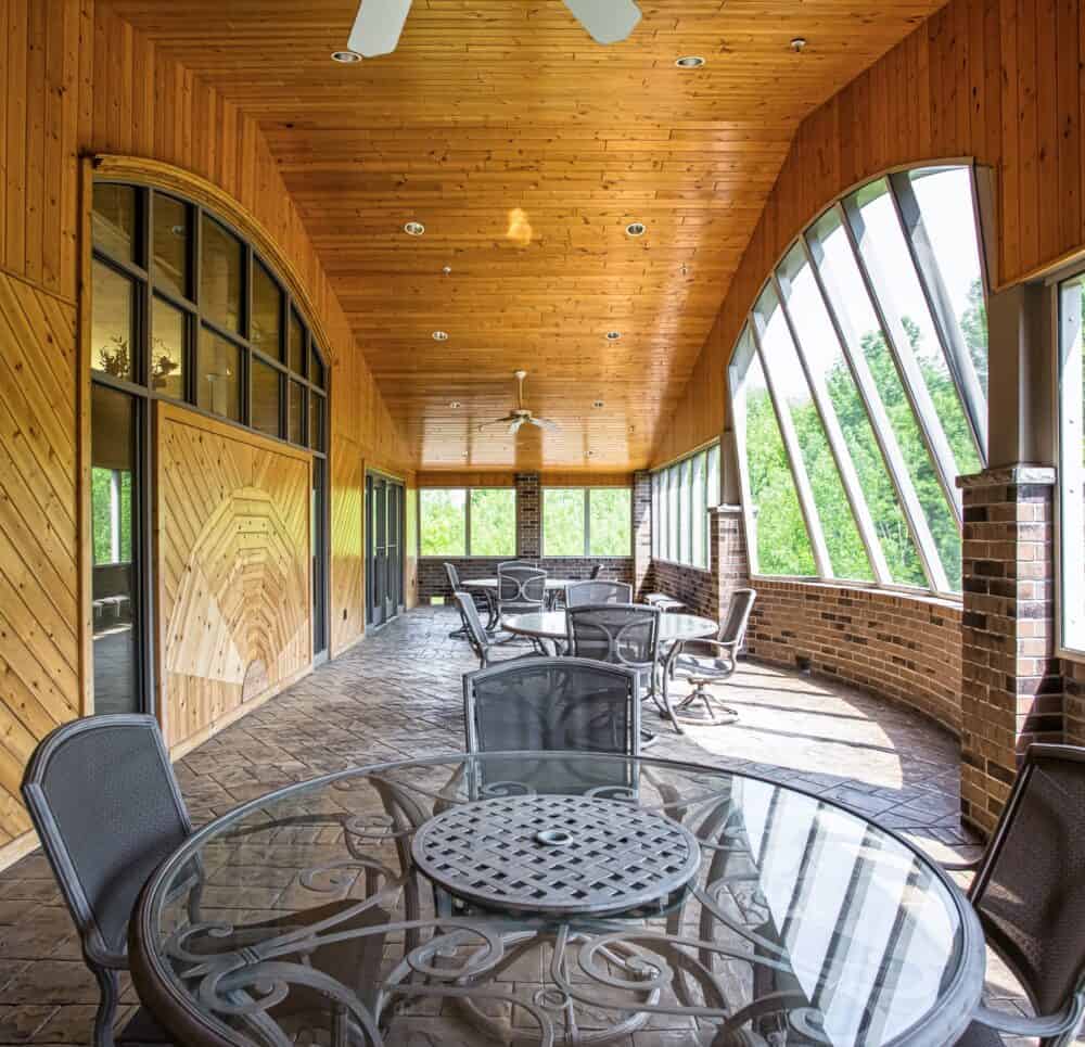 Sun room with seating overlooking the forest at senior living community in Green Bay, Wisconsin.