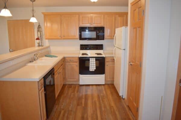 Full kitchen with refrigerator, stove, dishwasher and microwave at a senior living community in Green Bay, Wisconsin.