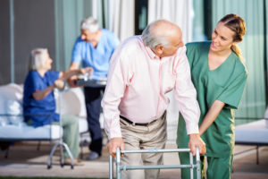 Nurse helping senior with a walker in a senior living community