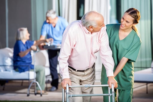 Nurse helping senior with a walker in a senior living community