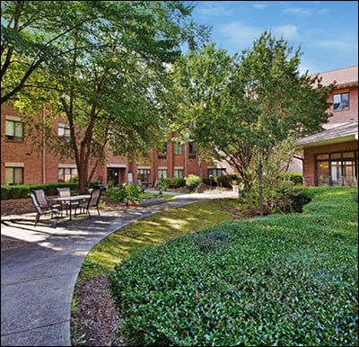 The Courtyards at Olde Raleigh Senior Living Community with lush landscaping and walking paths in Raleigh, NC