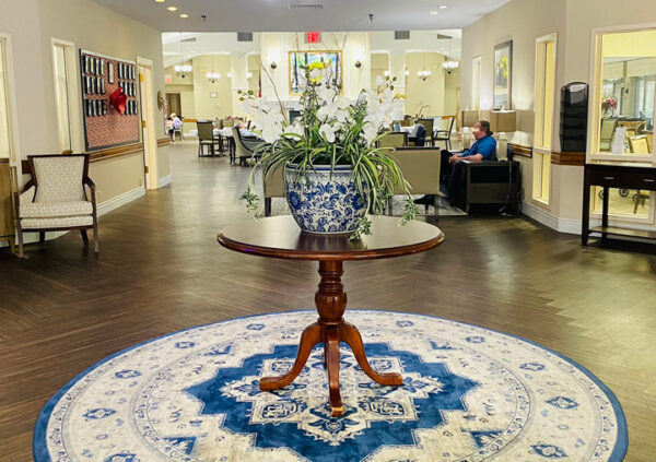 lobby entrance of a senior living community with a rug and large plant on a table