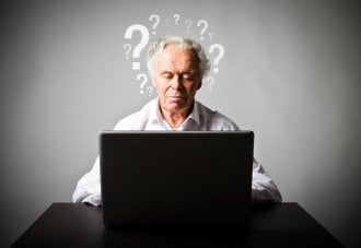 Senior man looks confused while looking at his computer.