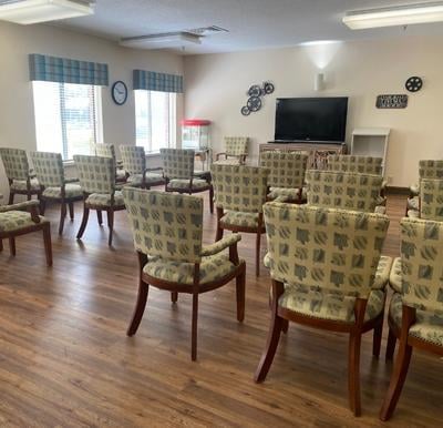 many chairs facing a TV and popcorn machine near windows