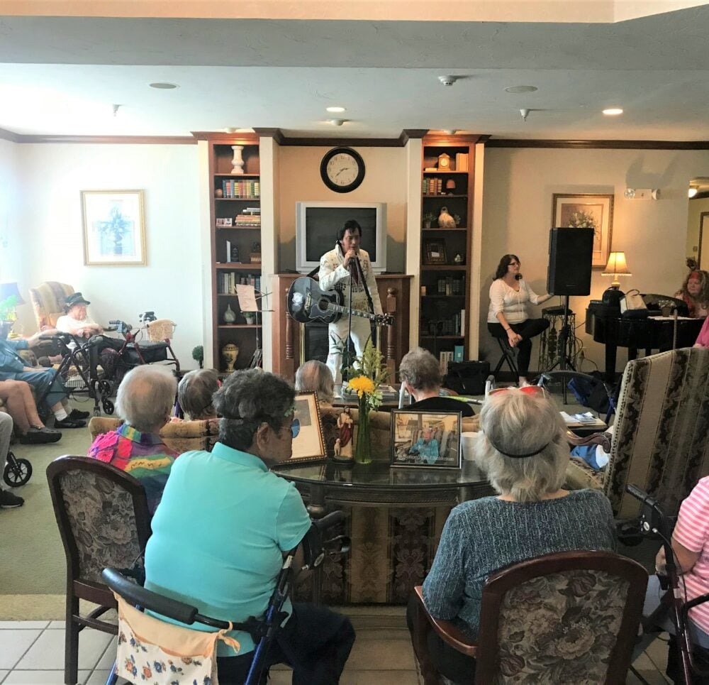 An Elvis impersonator sings for a group of seniors