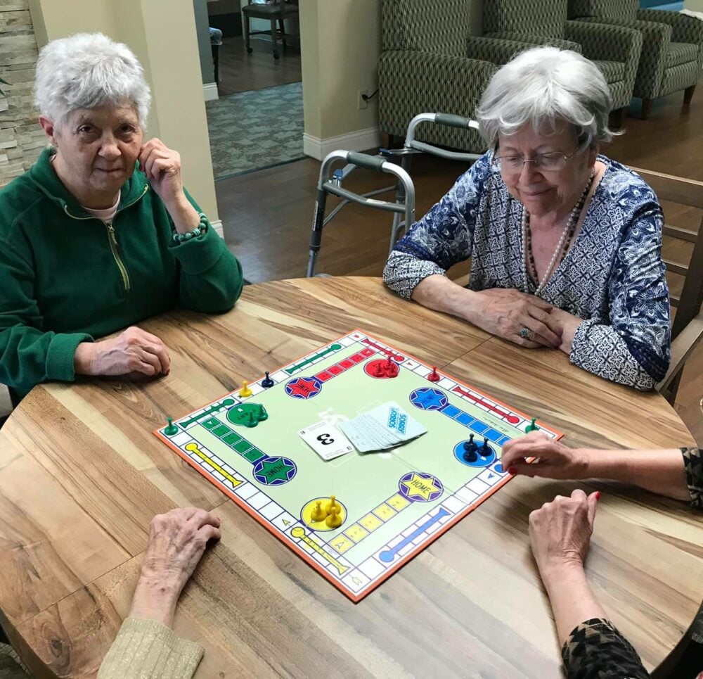 Group of senior women play a board game at a senior living community in Omaha, Nebraska.