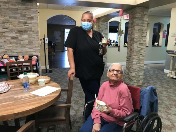 Senior woman and caregiver smile together at a senior living community in Omaha, Nebraska.