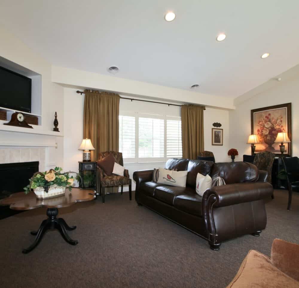 Lounge with couches and a TV at a senior living community in St. Joseph, Missouri.