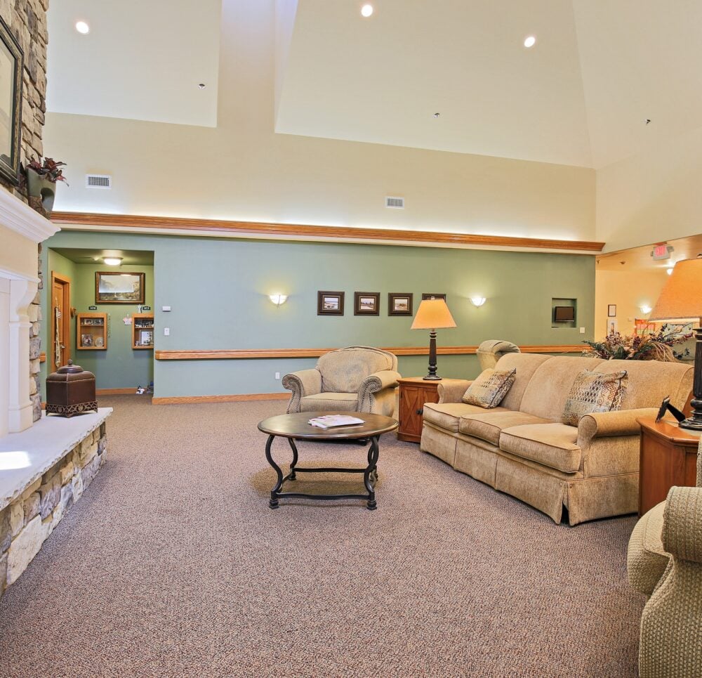 Lounge area with comfortable seating and fireplace at a senior living community in Wisconsin Rapids, Wisconsin.