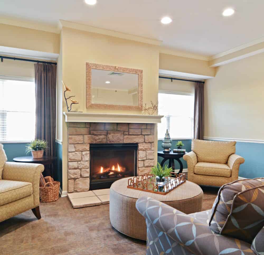 Lounge area at a senior living community with fireplace and comfortable seating in Chardon, Ohio.