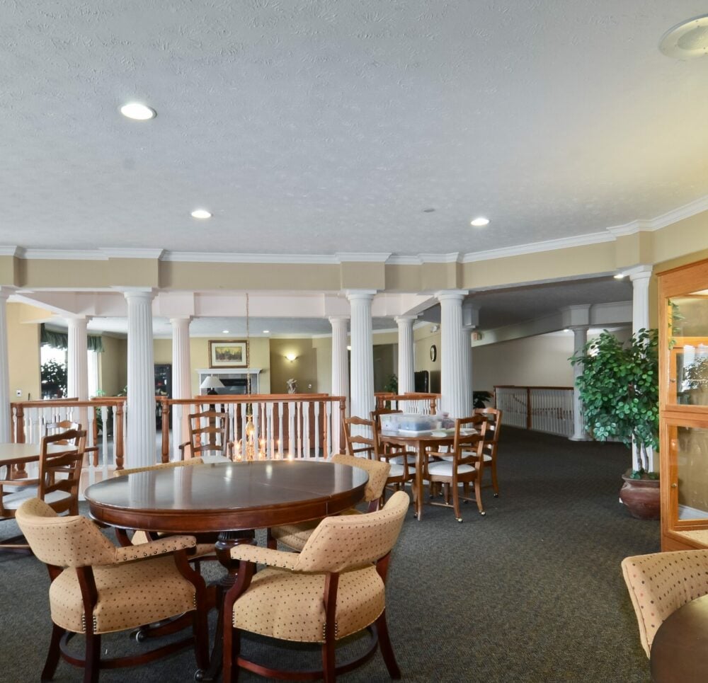 Seating and activity area with comfortable chairs and tables at a senior living community in Indianapolis, Indiana.