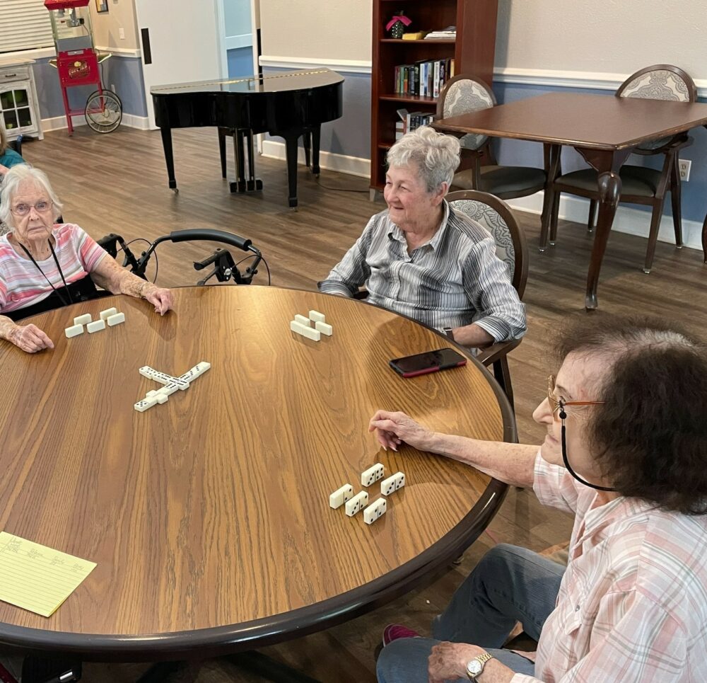 Three senior women play a game of Dominoes at a senior living community in Conroe, Texas