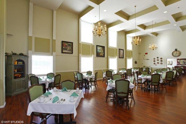 Dining room with vaulted ceiling, comfortable seating and ample natural light at a senior living facility in Omaha, Nebraska