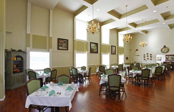 Dining room with vaulted ceiling, comfortable seating and ample natural light at a senior living facility in Omaha, Nebraska