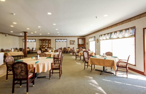 Open dining room with tables and chairs near a large window in Batesville, Indiana.