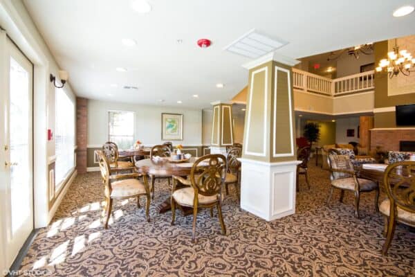Dining area at a senior living community in Conroe, Texas with chandeliers and comfortable seating.