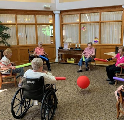 Residents at Aspen Grove senior living facility in Lambertville, Michigan exercise in a group.