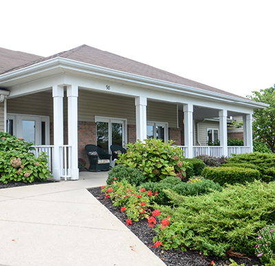 Beautiful covered patio with rocking chairs overlooking well-manicured landscaping in Greencastle, Indiana.