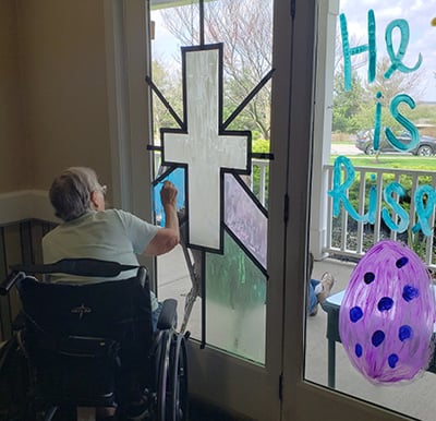 A senior woman painting a stained glass window in her retirement home in Green Castle, Indiana.