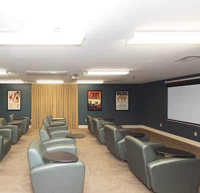 Movie theater room at a senior living community with oversized viewing chairs in Baytown, Texas.