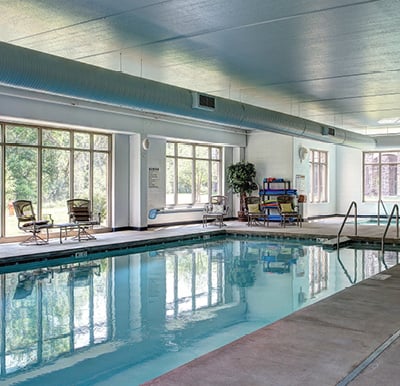 Window-lined indoor aquatic center pool and whirlpool at an independent living community in Green Bay, Wisconsin.