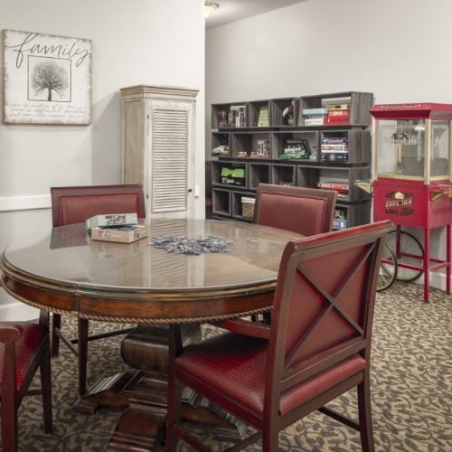 Activity area includes a table with a puzzle, a bookshelf with games and a popcorn machine