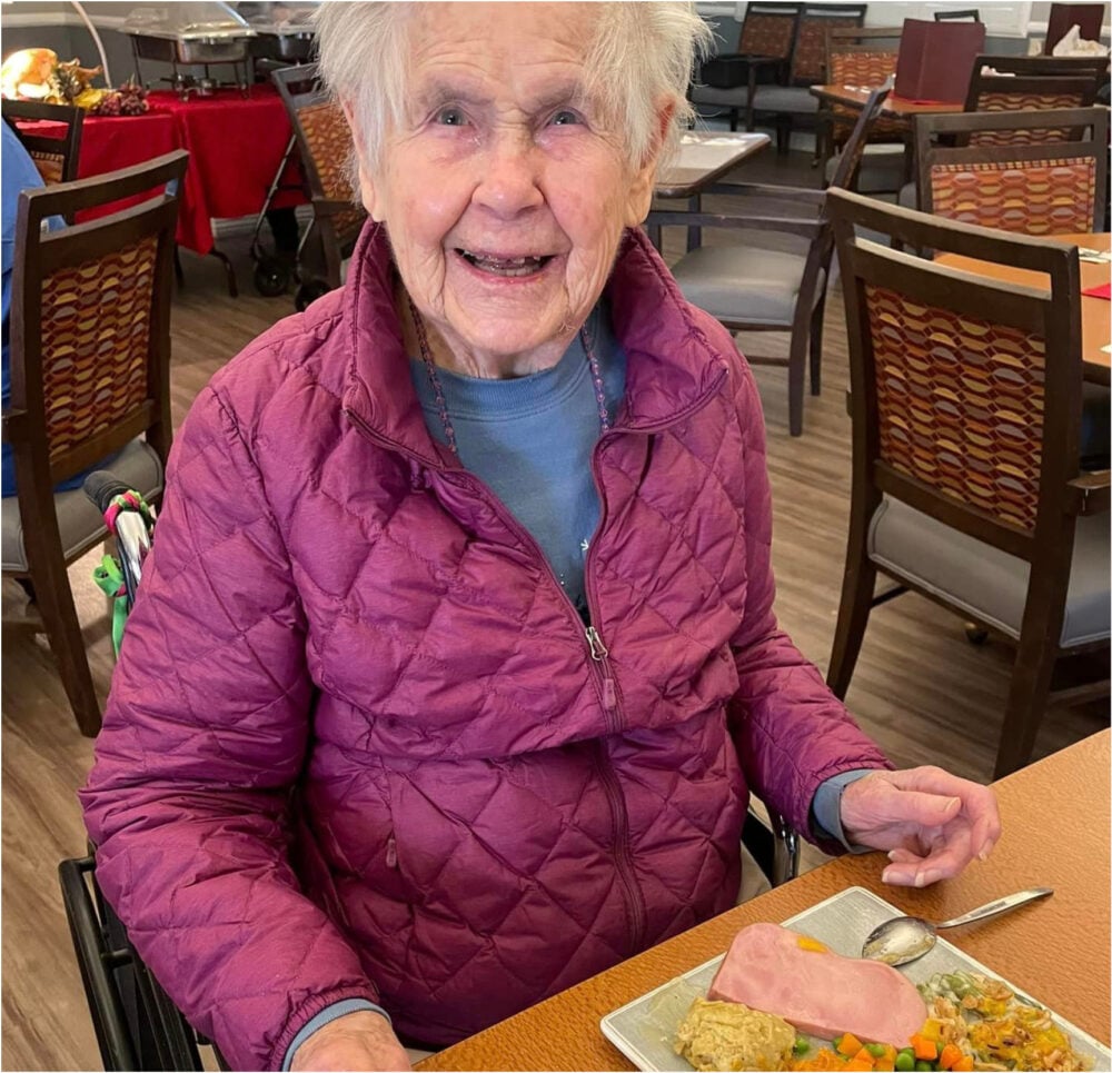 Senior woman smiles while eating her Thanksgiving dinner at a senior living community in Cottonwood, Arizona