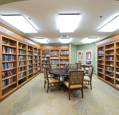 Beautiful library with walls lined with bookshelves and table seating in the middle of the room in East Lansing, Michigan.