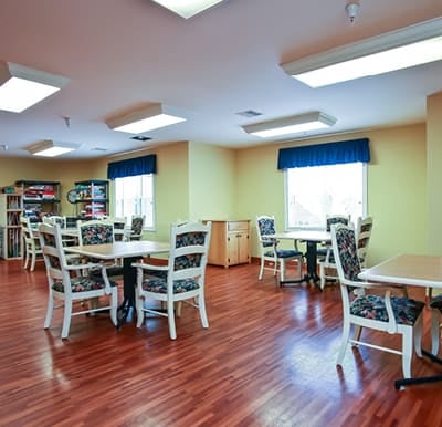 An activity center at a senior living facility with tables and chairs in Fitchburg, Wisconsin.