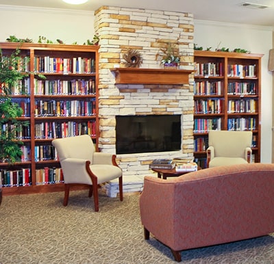 A fireplace with bookshelves surrounding it and comfortable lounge seating in Granbury, Texas.