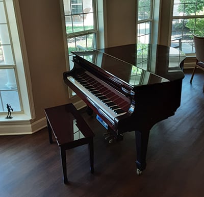 Grand piano in a lounge area with large windows in Hamilton, Ohio.