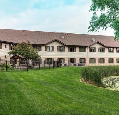 Fenced in patio with outdoor seating overlooking a peaceful pond in Hartford, Wisconsin.