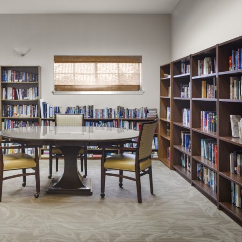 Library with wall-to-wall bookshelves and a seating area in San Antonio, Texas