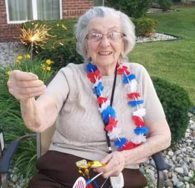 A senior woman holding a sparkler on the Fourth of July in Perrysburg, Ohio.