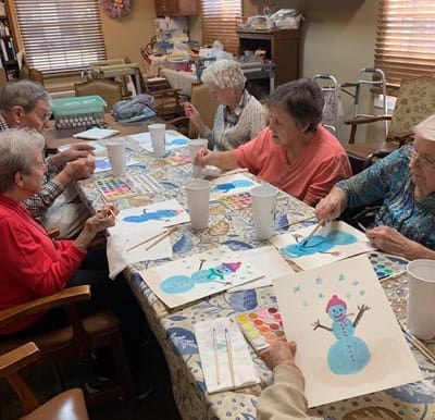 A group of senior women enjoying a craft in the activity room.