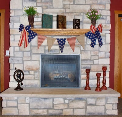 Fireplace with floor-to-ceiling stone and decorative bunting on the mantel in Park Falls, Wisconsin.