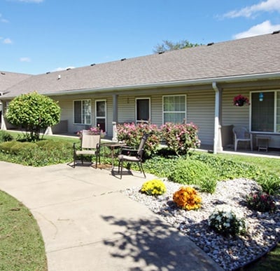 A walking path in an outdoor courtyard with comfortable seating and potted plants in Jeffersonville, Indiana.