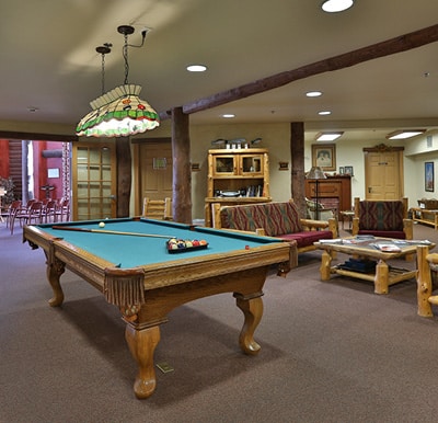 A spacious and open activity center with a billiards table and lounge area in Maple Grove, Minnesota.