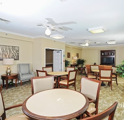 Spacious activity room with many tables and a big-screen TV in Indianapolis, Indiana.