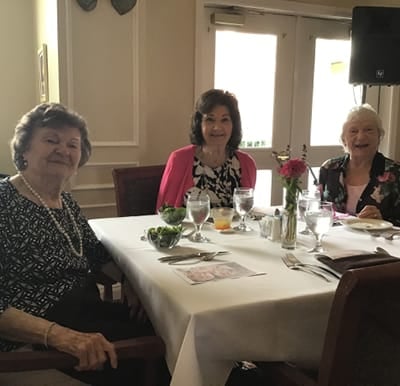 Three senior living residents enjoy a meal in their dining room in Macedonia, Ohio.