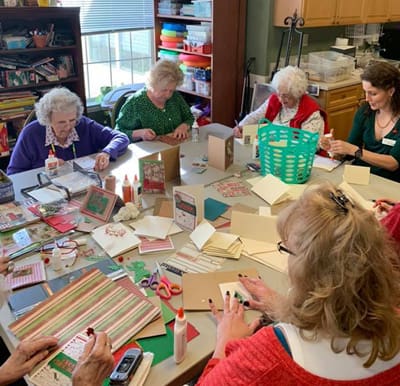 Senior women gathered around a table making Christmas crafts in Anderson, South Carolina.