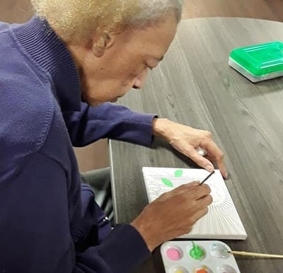 A senior woman painting a picture in Virginia Beach, Virginia.