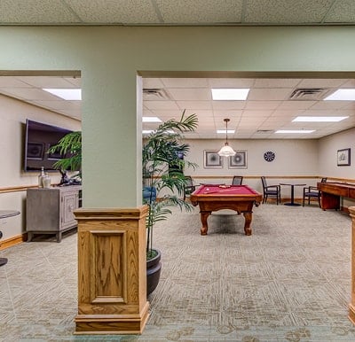 Senior living activity center in Hot Springs, Arkansas with billiards table and large screen flat TV.
