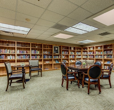 An overstocked library with games, tables and chairs in a senior living facility in Hot Springs, Arkansas.