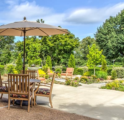 A landscaped courtyard at a senior living community with table and chairs in Hot Springs, Arkansas.