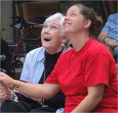 young woman and a senior woman admire a firework together during the fourth of july party