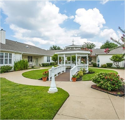 Large, white gazebo in the middle of a beautifully landscaped courtyard in Keller, Texas.
