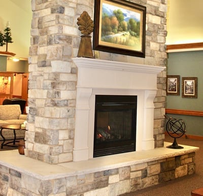 Beautiful, stone double-sided fireplace with mantel in Wisconsin Rapids, Wisconsin.