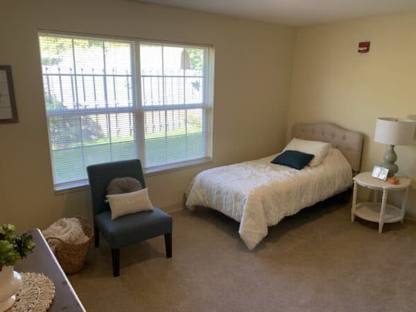 Studio apartment with twin size bed and seating area at senior living facility in Lambertville, Michigan.